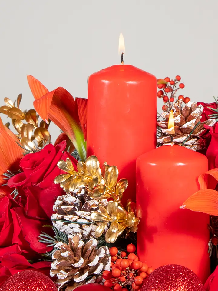 Centrotavola natalizio rosso di rose e amaryllis e 2 candele rosse macro